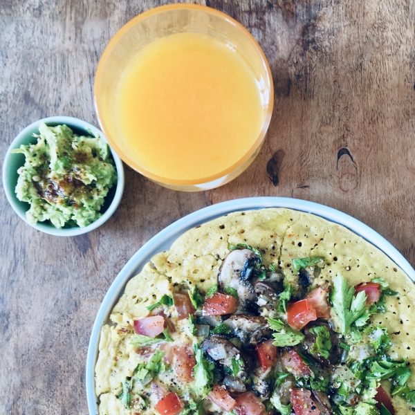 Chickpea omelette, mashed avocado, and fresh orange juice